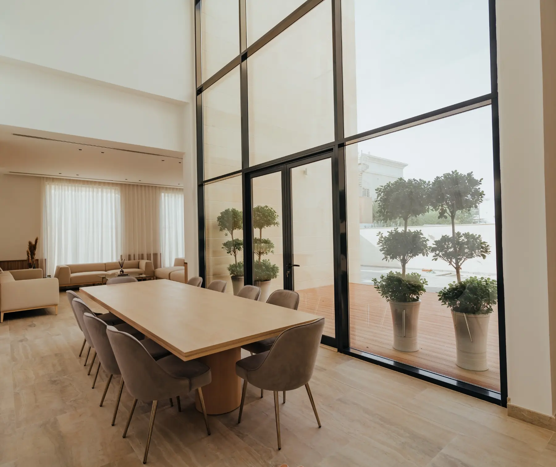 Double-height aluminium and glass curtain wall in a villa dining room
