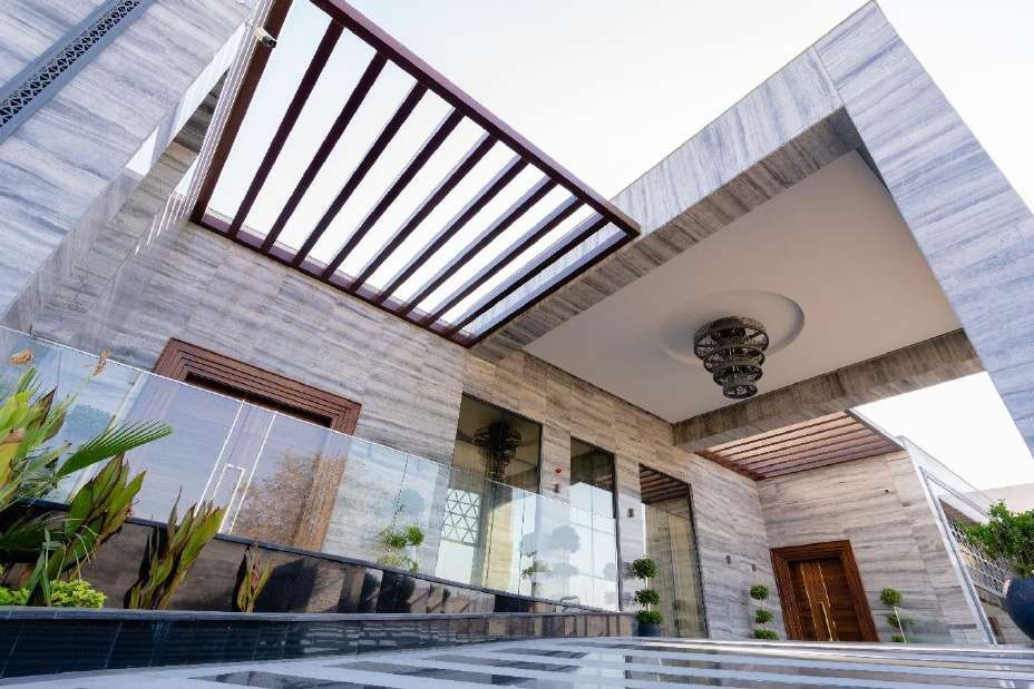 Glass pavilion with aluminium pergola beside a pool